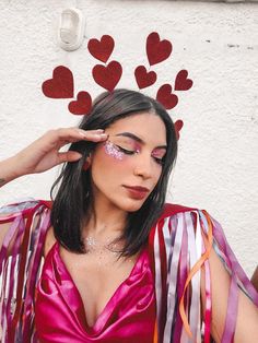 a woman in a pink dress with hearts painted on her face