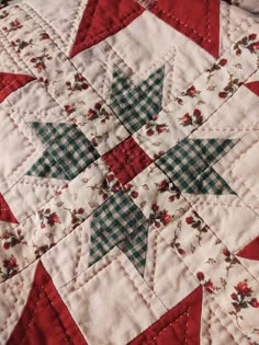 a red and white quilted table topper with green and blue stars on it