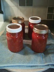 four jars filled with jam sitting on top of a towel