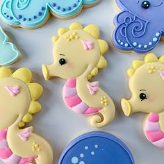 decorated baby shower cookies are displayed on a table