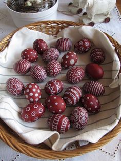 some red and white decorated eggs in a basket