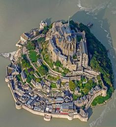 an aerial view of a castle in the middle of some water, with buildings on it