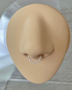 a white mannequin head with a ring on it