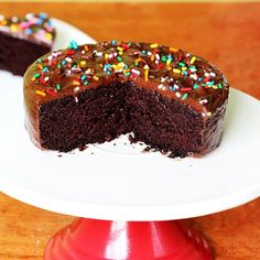 a piece of chocolate cake with sprinkles on it sitting on a plate