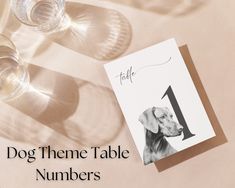 a table with wine glasses and a card that says dog theme table numbers