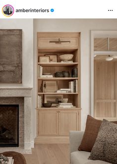 a living room filled with furniture and a fire place in front of a book shelf