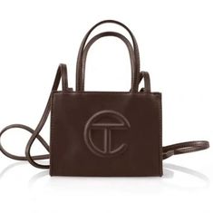 Brand New! Telfar Small Shopping Bag In Chocolate. "The Iconic Unisex Shopping Bag Is An Everyday Bag For Everyone. Featuring A Double Strap (Handles And Cross-Body Straps), Embossed Logo, And Magnetic Snap Closure. Made From Faux Leather And Twill Lining. Bag Is Packaged In A Drawstring Bag With Screen-Printed Logo." Height 4 3/4", Width 6 5/8", Depth 3", Strap Drop 21", Handle Drop 4 3/4" 50% Polyurethane, 50% Polyester Telfar Brown, Chocolate Bag, Telfar Bags, Telfar Handbags, Cotton Drawstring Bags, Medium Tote, Small Crossbody Bag, Shopper Bag, Everyday Bag