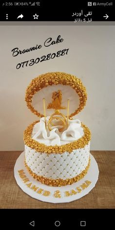 a three tiered cake decorated with gold and white icing