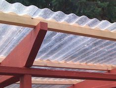 a bird perched on top of a wooden structure with metal roofing sheets covering it