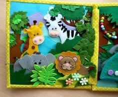 an open book with felt animals and trees