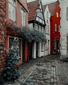 an old cobblestone street lined with red and white brick buildings in the city