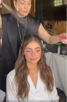 a woman is getting her hair done by another woman