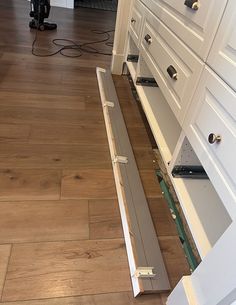 an open drawer in the middle of a kitchen floor that has been stripped and installed