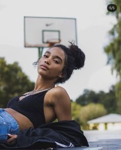 a woman laying on the ground in front of a basketball hoop