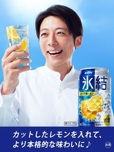 a man holding up a can of soda and a glass with lemon slices in it