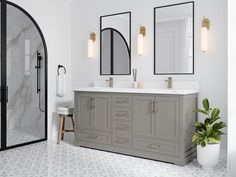 a bathroom with two sinks and mirrors on the wall, along with a potted plant