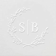 the monogrammed logo is shown in white with an elegant wreath around it and the initials