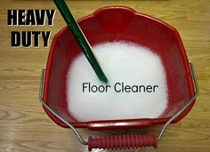 a red bucket filled with white foam and a green handled brush on top of it