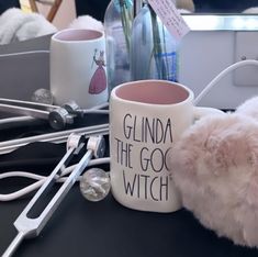 a white mug sitting on top of a table next to some scissors and other items