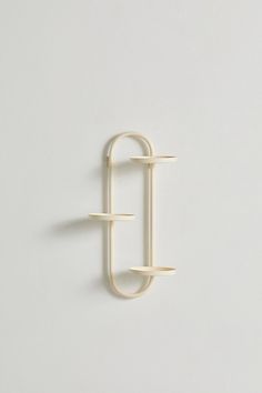 a white wall mounted hook on the side of a wall