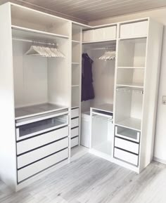 an empty walk in closet with white shelves and drawers