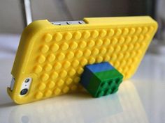 a yellow case with legos on it sitting next to a green and blue object