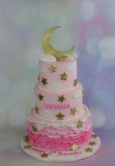 a pink cake with gold stars and a moon on top