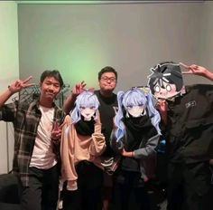 some people are posing for a photo with anime characters on their heads and one is wearing a mask