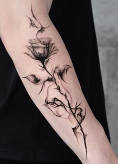 a woman's arm with a flower tattoo on it