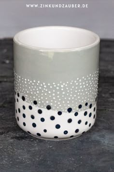 a white and black polka dot cup sitting on top of a table