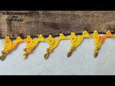 yellow crocheted birds are lined up on the side of a piece of fabric