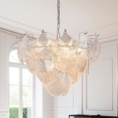 a chandelier hanging from the ceiling in a room with white walls and flooring