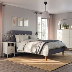 a bedroom with a bed, dressers and windows in it's center area