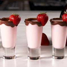 three shot glasses filled with chocolate and strawberries