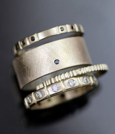 two gold wedding bands with diamonds on them