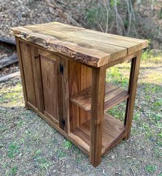 a wooden table sitting on top of a grass covered field next to a wooded area