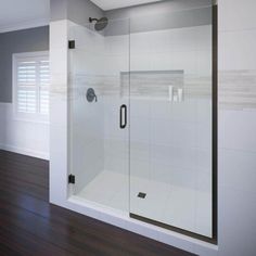 an empty bathroom with wood floors and white walls, including a walk - in shower