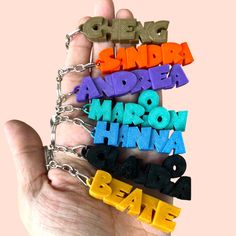 a hand holding four different colored letters on it's chain that spell out the word love