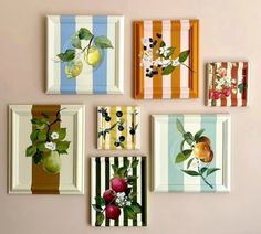 six framed pictures hanging on the wall with fruit and flowers painted on them in different colors