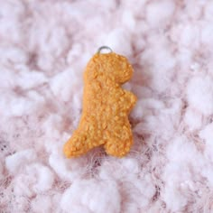 a close up of a stuffed animal on a pile of wool with cotton in the background