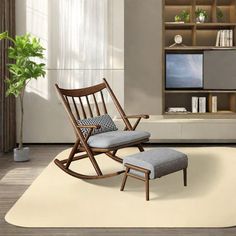 a living room with a rocking chair and footstool in front of a flat screen tv