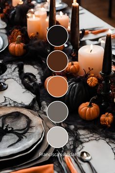 a table topped with candles and plates covered in halloween decorations