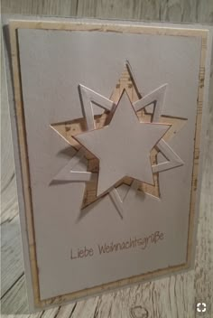 a white card with a star cut out of it's center on a wooden table