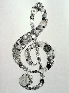 a musical note made out of buttons and other beads on a white background with the word music written below it