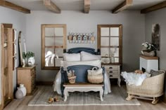 the bedroom is decorated in neutral colors and features wicker baskets on the bed, white linens, and wooden furniture