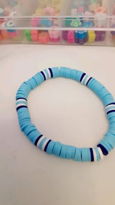 a blue and white beaded bracelet sitting on top of a table next to markers