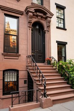 a building with stairs leading up to the front door and windows on each side of it