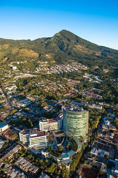 an aerial view of a city with mountains in the background and buildings on both sides