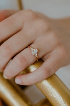 a close up of a person's hand with a gold ring on top of her finger