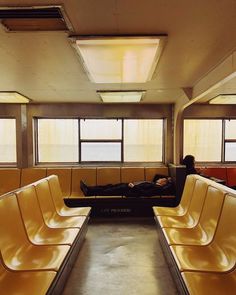 a man laying on a bench in an empty room